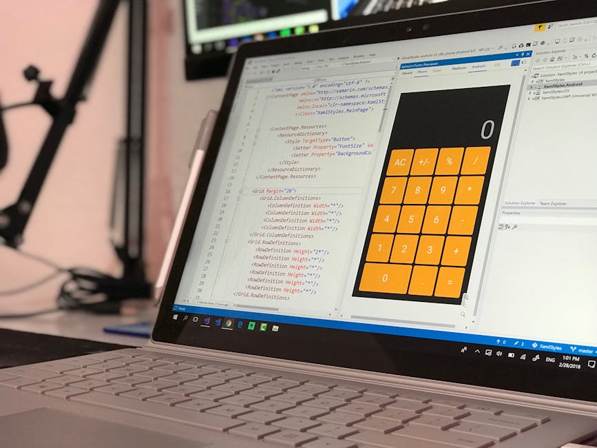 A close-up view of a silver laptop displaying a spreadsheet with lines of HTML code on the left side and a large orange calculator interface on the right side. The laptop is placed on a desk with a bl